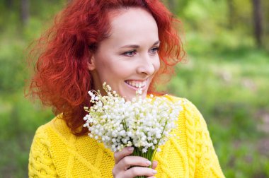 Sarı süveterli, beyaz çiçekli, kızıl saçlı, nazik genç bayanı kapatın. Gün ışığındaki kız