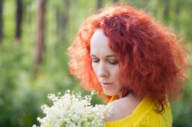 Sarı kazaklı, çıplak omuzlu, beyaz çiçekli kızıl saçlı romantik kız.