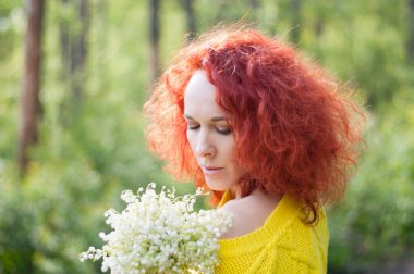 Sarı kazaklı, çıplak omuzlu, beyaz çiçekli kızıl saçlı romantik kız.