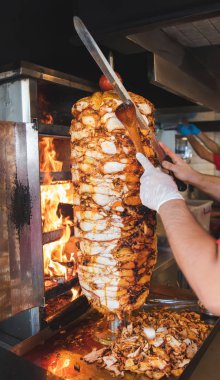 Aşçı, geleneksel Türk Donör Kebap etiyle kesiyor. Shawarma veya jiroskoplar. Türkçe, Yunanca ya da Ortadoğu tarzında izole edilmiş beyaz kebap.
