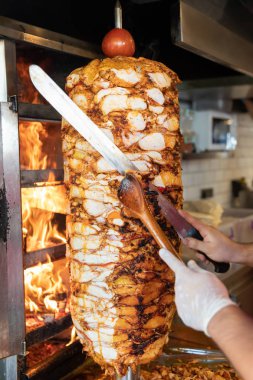 Aşçı, geleneksel Türk Donör Kebap etiyle kesiyor. Shawarma veya jiroskoplar. Türkçe, Yunanca ya da Ortadoğu tarzında izole edilmiş beyaz kebap.
