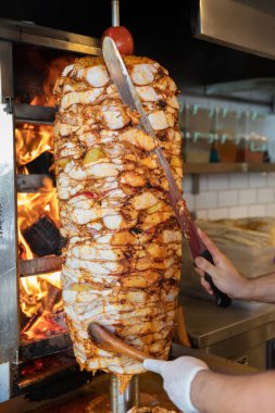 Aşçı, geleneksel Türk Donör Kebap etiyle kesiyor. Shawarma veya jiroskoplar. Türkçe, Yunanca ya da Ortadoğu tarzında izole edilmiş beyaz kebap.