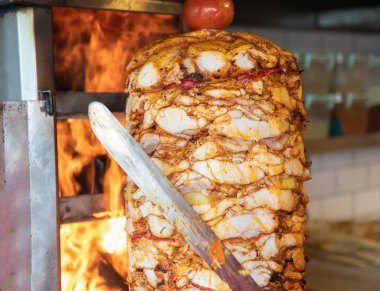 Aşçı, geleneksel Türk Donör Kebap etiyle kesiyor. Shawarma veya jiroskoplar. Türkçe, Yunanca ya da Ortadoğu tarzında izole edilmiş beyaz kebap.