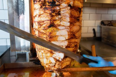 Aşçı, geleneksel Türk Donör Kebap etiyle kesiyor. Shawarma veya jiroskoplar. Türkçe, Yunanca ya da Ortadoğu tarzında izole edilmiş beyaz kebap.