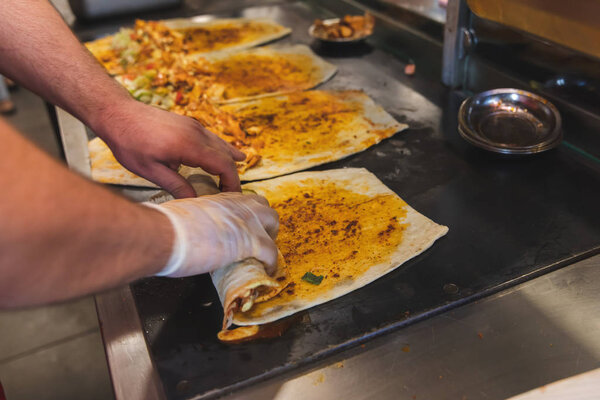 Chef preparing and making Traditional Turkish Doner Kebab meat. Shawarma or gyros. Turkish, greek or middle eastern arab style chicken doner kebab food on isolated white.