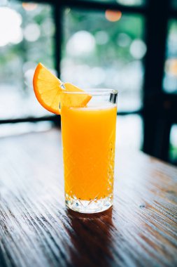 Taze, lezzetli, sağlıklı, portakal suyu ve eski ahşap masadaki dilimler.