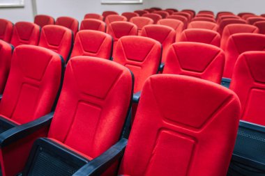 Tiyatroda kırmızı sinema sandalyeleri ya da koltuklar. Konferansta veya seminer odasında kırmızı sandalyeler.