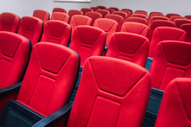Tiyatroda kırmızı sinema sandalyeleri ya da koltuklar. Konferansta veya seminer odasında kırmızı sandalyeler.