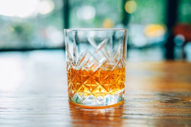 Geceleri pub, bar veya restoranda ahşap masada tek bardak viski veya viski. Tahta masada viski, burbon veya İrlanda viskisi. Gece hayatı konsept görüntüsü