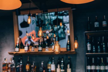 Kafede vintage lüks iç aydınlatma dekor. eski Vintage ampul lambaları. Restaurant Bar aydınlatma iç tasarım. Alkollü içecek şişeleri önünde şarap odasında Vintage Ampuller