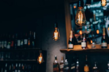 Kafede vintage lüks iç aydınlatma dekor. eski Vintage ampul lambaları. Restaurant Bar aydınlatma iç tasarım. Alkollü içecek şişeleri önünde şarap odasında Vintage Ampuller