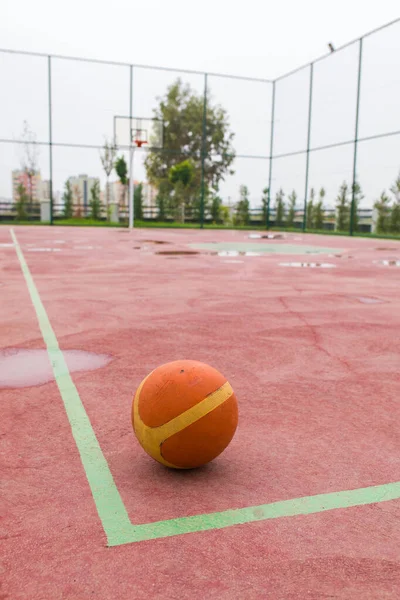 Open air, outdoor Basketball court. Basket ball in Basketball court. Red Basketball court.