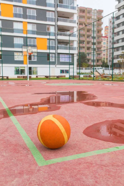 Open air, outdoor Basketball court. Basket ball in Basketball court. Red Basketball court.