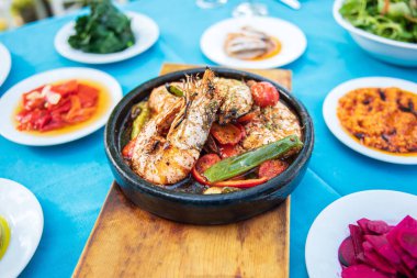 Karides, Deniz Ürünleri, mezeler ve salatalar Fish Restaurant'ta masada. Yunanistan veya Türkiye'de Beach Restaurant. Bodrum, Santorini veya Mikonos'ta Ege sahili, Yunan veya Türk tarzı balık restoranı