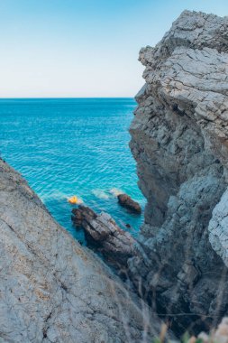 Denizde taş kaya, okyanus ve mavi gökyüzü. Denizin ufku ve mavi temiz gökyüzü.