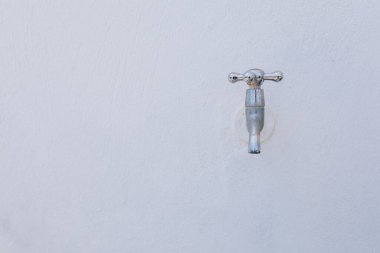 Eski ve kullanılmış metal antika musluk beyaz duvarda..