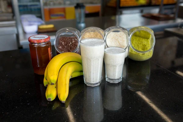 Banana juice smoothie milk shake with some ingredients. Blender with full of milk, banana and honey. Smoothies maker. Milk shaker
