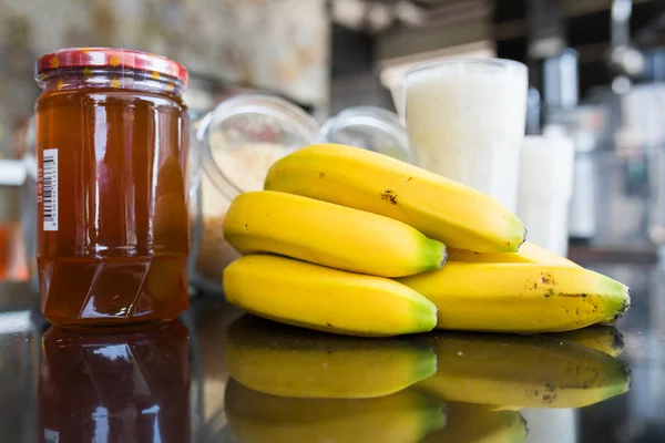 Banana juice smoothie milk shake with some ingredients. Blender with full of milk, banana and honey. Smoothies maker. Milk shaker