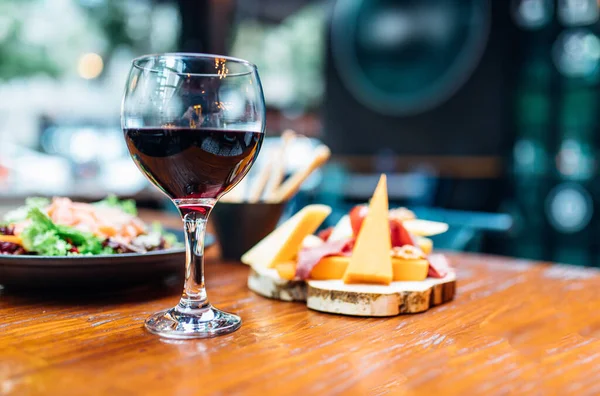 Rotweinglas Vorhanden Verschiedene Käseteller Und Räucherlachssalat Auf Einem Hölzernen Esstisch — Stockfoto