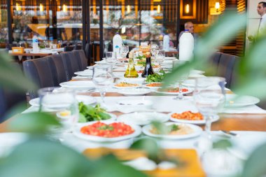 Kapalı ya da açık havada Yunan ya da Türk tarzı restoran yemeği ya da salata ve aperatifli yemek masası. Yemek masası kurulumu