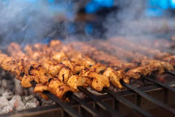 Chicken shish Kebab or kebap meat on metal skewer barbecue and embers in the Turkish restaurant. Skewering bbq Chicken Kebab..