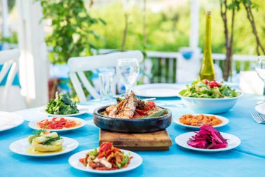 Shrimp, Seafoods, appetizers and salads on the table in Fish Restaurant. Beach Restaurant in Greece or Turkey. Aegean seaside, Greek or Turkish style fish restaurant in Bodrum, Santorini or Mykonos clipart