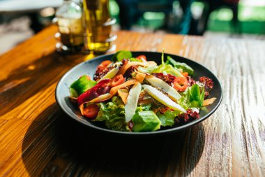 Sağlıklı salata için taze, lezzetli malzemeler ahşap masa altyapısı, üst manzara, pankart. Diyet ya da vejetaryen gıda konsepti. Akdeniz yeşil salatası grunge sehpasında siyah tabakta. 