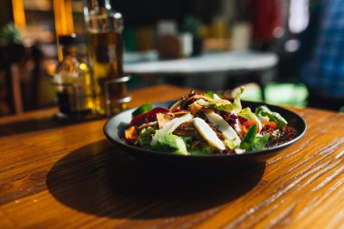 Sağlıklı salata için taze, lezzetli malzemeler ahşap masa altyapısı, üst manzara, pankart. Diyet ya da vejetaryen gıda konsepti. Akdeniz yeşil salatası grunge sehpasında siyah tabakta. 