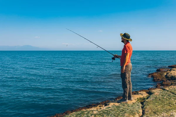 Pescador Pie Lanzar Una Caña Pescar Mientras Pesca Mar Temporada — Foto de Stock