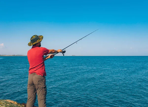 Pescador Pie Lanzar Una Caña Pescar Mientras Pesca Mar Temporada —  Fotos de Stock