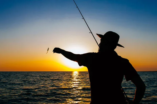 Silueta Pescador Pie Lanzar Una Caña Pescar Mientras Pesca Mar —  Fotos de Stock