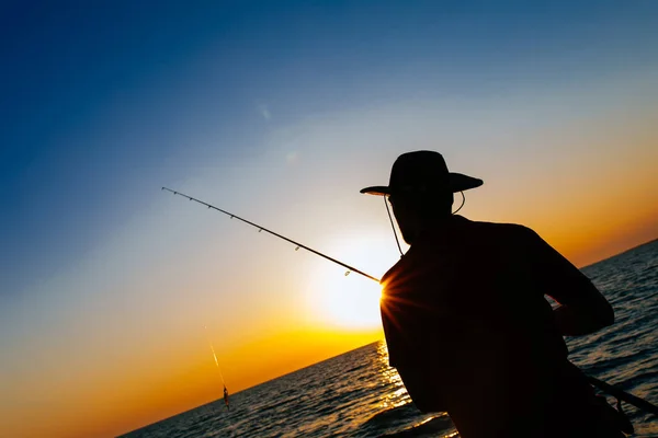 Silueta Pescador Pie Lanzar Una Caña Pescar Mientras Pesca Mar —  Fotos de Stock