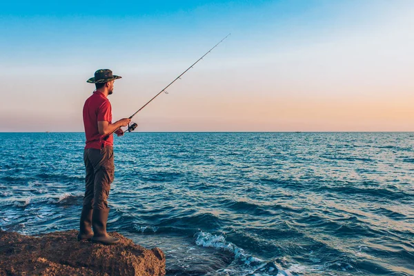 Pescador Pie Lanzar Una Caña Pescar Mientras Pesca Mar Temporada —  Fotos de Stock