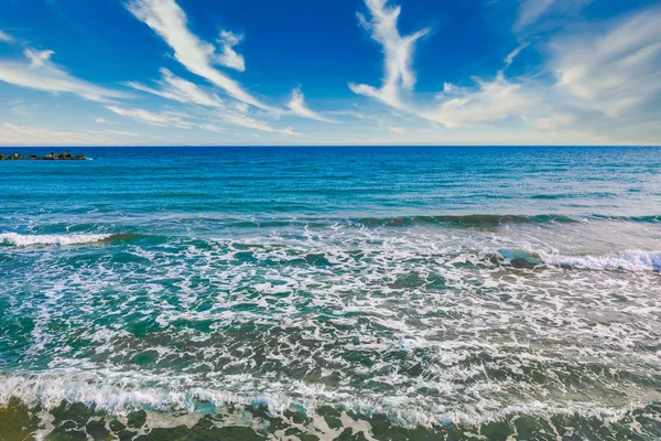 Beautiful clean blue sky, clouds, sea or ocean and waves at the beach in sunny day at summer time season. Sea and sky background.