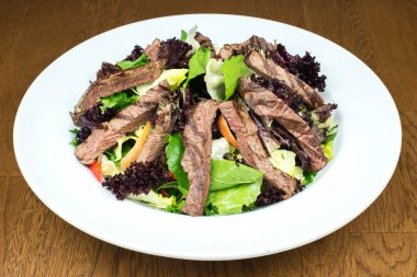 Sebzeli tabakta yemek için Asya usulü kızarmış biftek ya da ızgara yeşil salata. Sağlıklı beslenme yemeği