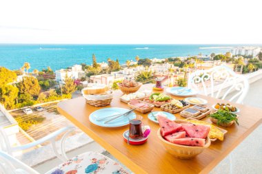 Oteldeki kumsalda kahvaltı ya da yaz mevsiminde deniz kenarında tatil. Tatil ve tatil kahvaltısı görüntüsü. Türkiye veya Yunanistan 'ın Bodrum kentinde geleneksel Türk veya Yunan kahvaltısı