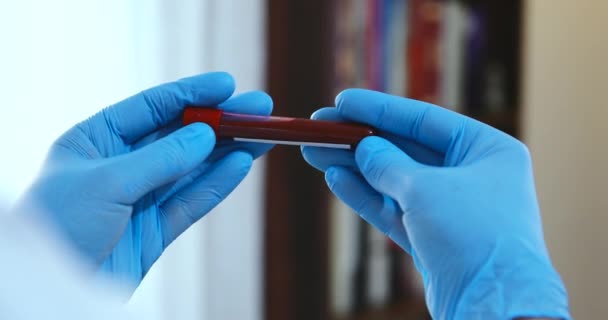 Doctor Holding Pandemic Coronavirus 2019-nCoV Blood Sample Positive Test Tube. Doctor wearing medical mask and gloves and shows patient's blood test tube containing corona virus (COVID-19) — Stock Video