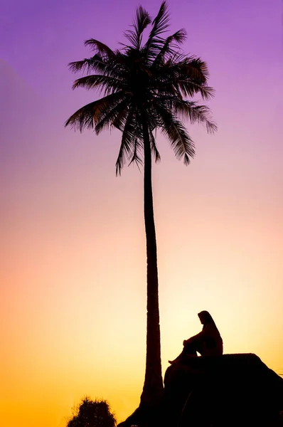 Силуэт кокосового дерева и молодая мусульманка — стоковое фото