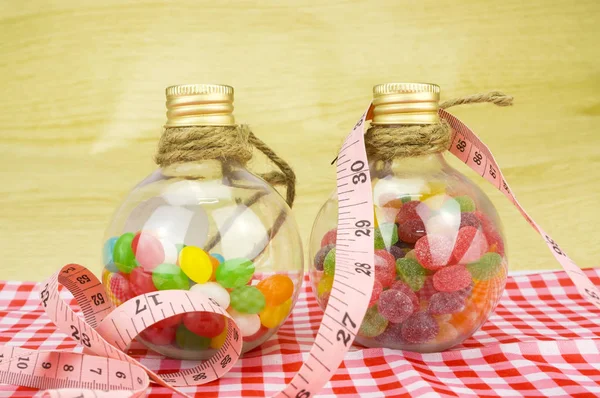 Colorful candies in bottles and tape measure with shallow depth of field (dof) — Stock Photo, Image