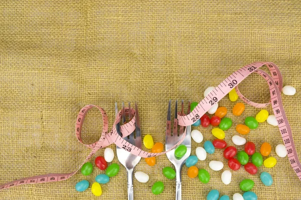 Colorful candies fork and tape measure with shallow depth of field (dof — Stock Photo, Image
