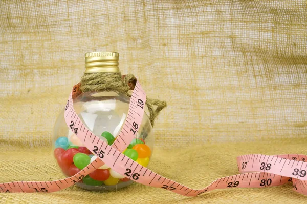 Барвисті цукерки в пляшках і стрічка міра з невеликою глибиною різкості ( Dof ) — стокове фото