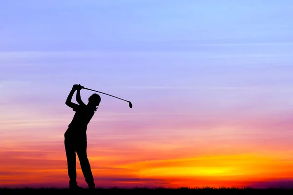 Silhueta golfista jogar golfe durante belo pôr do sol — Fotografia de Stock