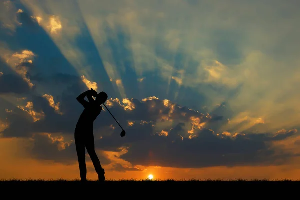 Silhueta golfista jogar golfe durante belo pôr do sol — Fotografia de Stock