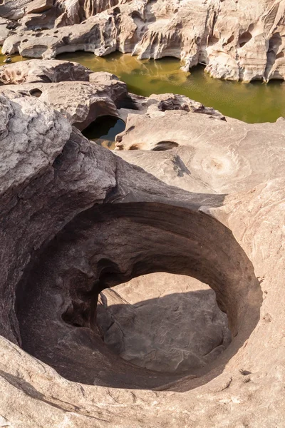 The stone hole caused by the water erode in Mekhong river after — Stock Photo, Image