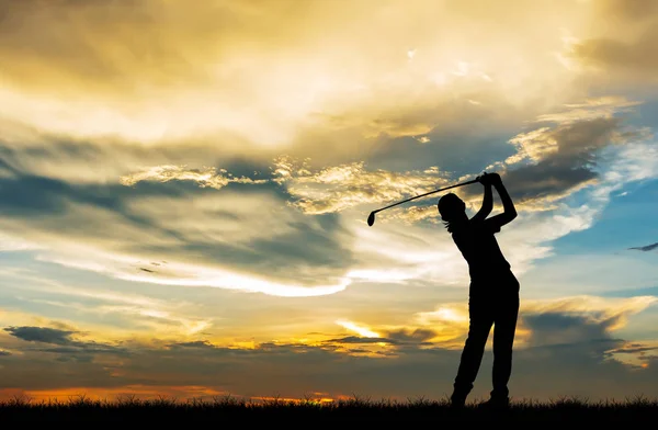 在美丽的日落期间打高尔夫球的剪影高尔夫球手 — 图库照片