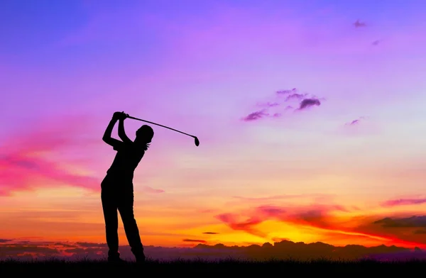 Silhueta golfista jogar golfe durante belo pôr do sol — Fotografia de Stock