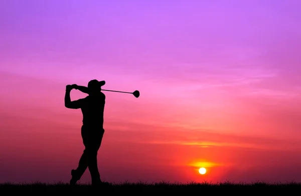 Silhueta golfista jogar golfe durante belo pôr do sol Imagens Royalty-Free