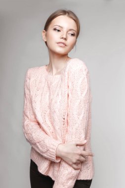 Aydınlık, geniş Studio'da şık rahat ve basit elbise gri bir arka plan ile poz bir kızın moda portre. temiz cilt ve mükemmel yüz genç kızla 