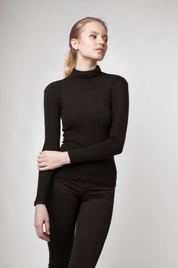 Aydınlık, geniş Studio'da şık rahat ve basit elbise gri bir arka plan ile poz bir kızın moda portre. temiz cilt ve mükemmel yüz genç kızla 