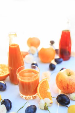 Güzel meyve beyaz zemin üzerine koydu. Şişe ve bardak parlak güneş parlar. ev bahçe taze ve sulu meyve